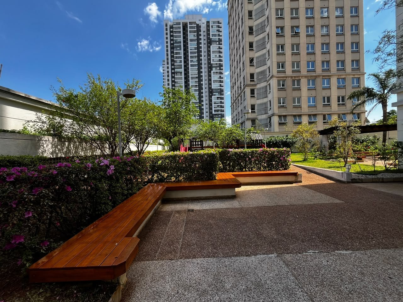 Banco corrido de madeira e jardim florido no Vila Imperial Ipiranga
